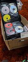 Cardboard box containing two black CD binder wallets filled with discs
