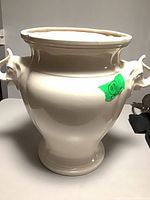 Front view of white ceramic umbrella stand with elephant head handles