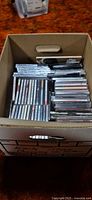 Box containing roughly fifty CDs in various cases