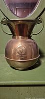 Front view of brass spittoon showing full shape and handles