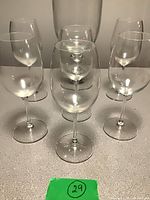 Front view of six clear wine glasses standing in two rows