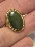 Top view of oval green cabochon ring with rope bezel