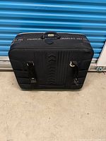 Front and side view of black Charles Delon suitcase