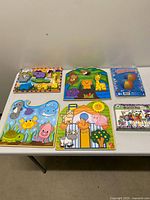 All items on table: four puzzles, LeapFrog pack, beach balls