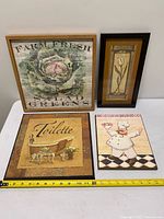 All four framed prints arranged together with measuring tape for scale