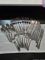 Full flatware set laid out showing all pieces and mirror finish