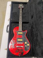 Full view of guitar in case showing body, neck and case interior