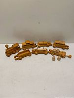 Entire wooden train set laid out disassembled showing locomotive, six cars and cargo pieces