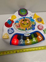 Front view of piano showing all buttons and tape measure for size