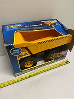 Truck in box with measuring tape showing length