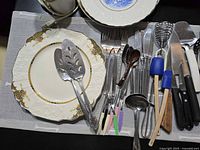 Overview showing Alfred Meakin plate, floral plates, mixed flatware and utensils