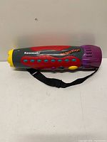 Left side view showing multicolor body, control buttons, shoulder strap