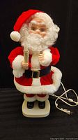 Front view of Santa figure showing candle, suit, and cord