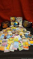 Wide view of loose cards, Poké Ball tin, two elite trainer boxes, Boltund V and Lugia GX cards