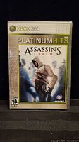 Front view of sealed Assassin's Creed Platinum Hits Xbox 360 game case