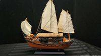 Port side view of wooden sailboat model on stand