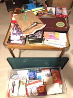 Overall lot on table and bin showing Scrabble box, envelopes, cards, tissue paper