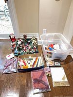 Group view of figurines, candles, linens, plastic tote
