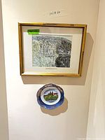 Framed David Milne print and decorative plate on wall