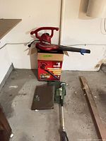 Toro blower vac on top of box, jack and pad on floor