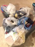 Multiple clear plastic bags filled with clothing and linens