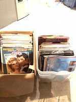 Cardboard box and plastic bin filled with vinyl records