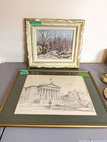 Two framed artworks on surface