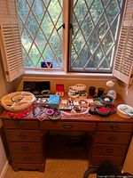 Full desk view with jewelry spread across surface and inside drawers
