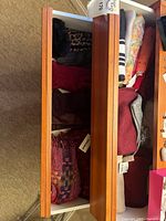 Drawer overview with gloves and multiple scarves, tags visible