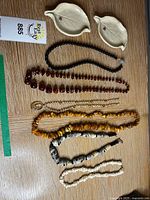 Group view of six necklaces and two leaf trinket dishes