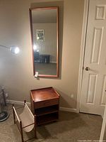 Overall view of mirror, side table, magazine rack