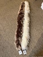 Curly brown tip and off-white Danier scarves laid out on carpet