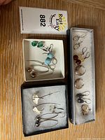 Overview of three jewellery boxes displaying multiple pairs of sterling silver earrings