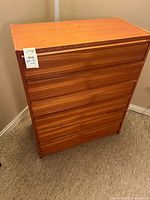 Front view of teak six-drawer dresser