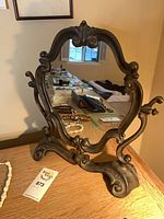 Front view of cast iron mirror on wood surface