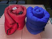 Red and blue rolled sleeping bags side by side