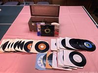 Spread of 45 RPM singles, sleeves, adapters, and storage box