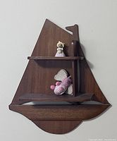 Full view of sailboat shelf mounted on wall with small figurines for scale