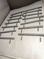Group of stainless T-bar pulls laid out on cushion