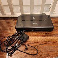 Canon PIXMA iP110 printer front view with power adapter