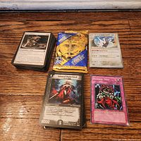 All components laid out – two stacks of cards, sealed booster, two single cards