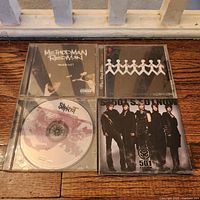 Four CD jewel cases showing front covers and one disc