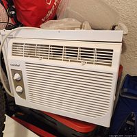 Front view of Comfee window AC showing grille, control knobs and overall condition