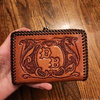 Front showing monogram and tooling, whipstitched edge, kiss-lock frame