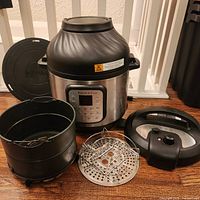 Full view of cooker base with both lids, basket and trivet