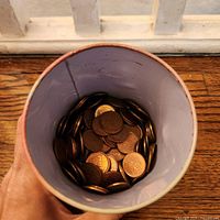 View inside cup showing numerous Canadian one-cent coins