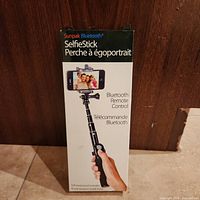 Front view of retail box for Sunpak Bluetooth Selfie Stick with image of product and included remote