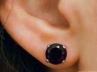 Garnet stud earring worn on ear