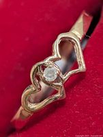 Close-up of heart motif and diamond on ring