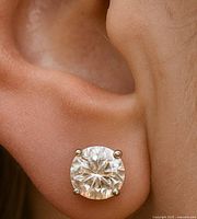 Close-up of earring worn in ear showing diamond size and prong setting